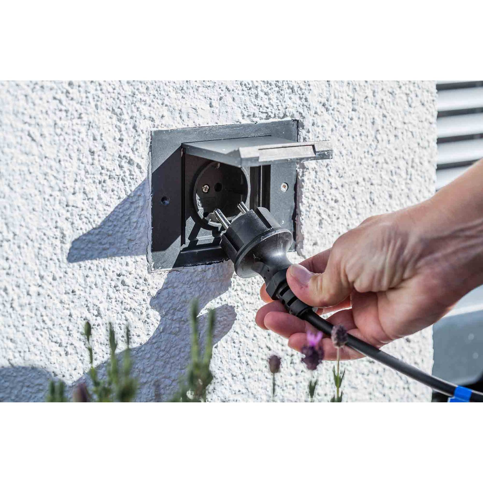 Heissner 015196-00 Rattan Terrassen-Hochteich mit Wasserspiel, schwarz Hand hält Stecker vor Außensteckdose